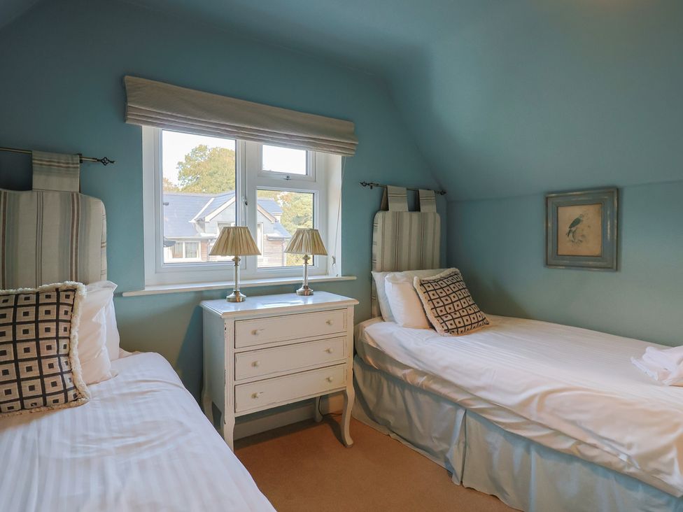 A bedroom with two beds and a dresser at Westhaven in Lyme Regis