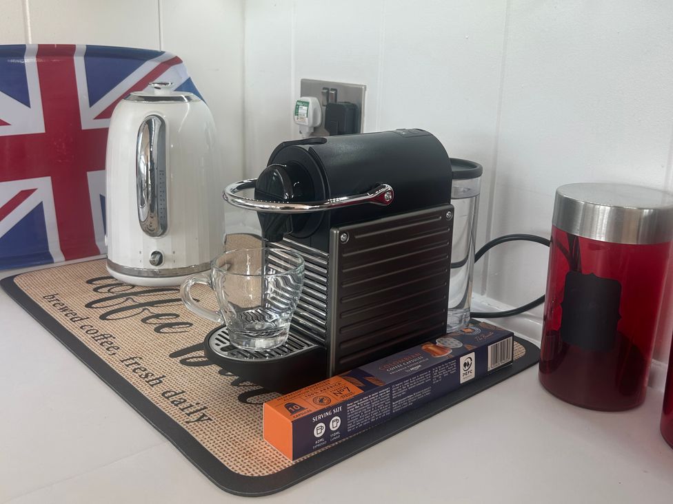 A coffee machine with a kettle and coffee cup at High Bullen Lodge Morcombelake