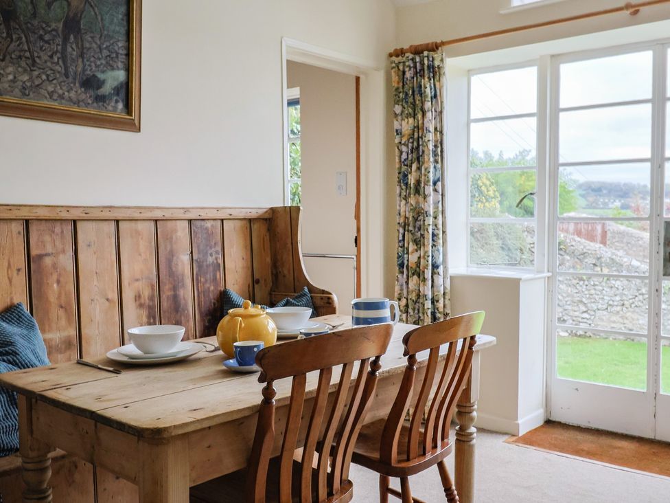 A dining room with a table set for a meal at Penny Plot Cottage in Lyme Regis