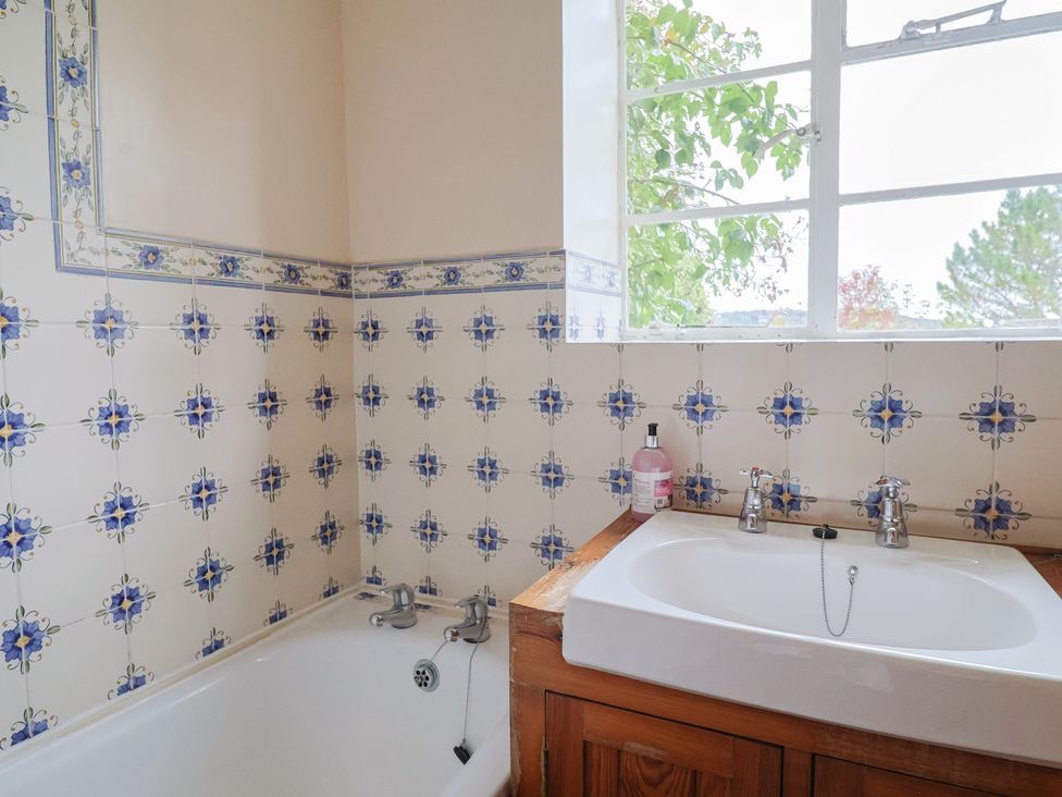 A bathroom with a bathtub and sink at Penny Plot Cottage in Lyme Regis