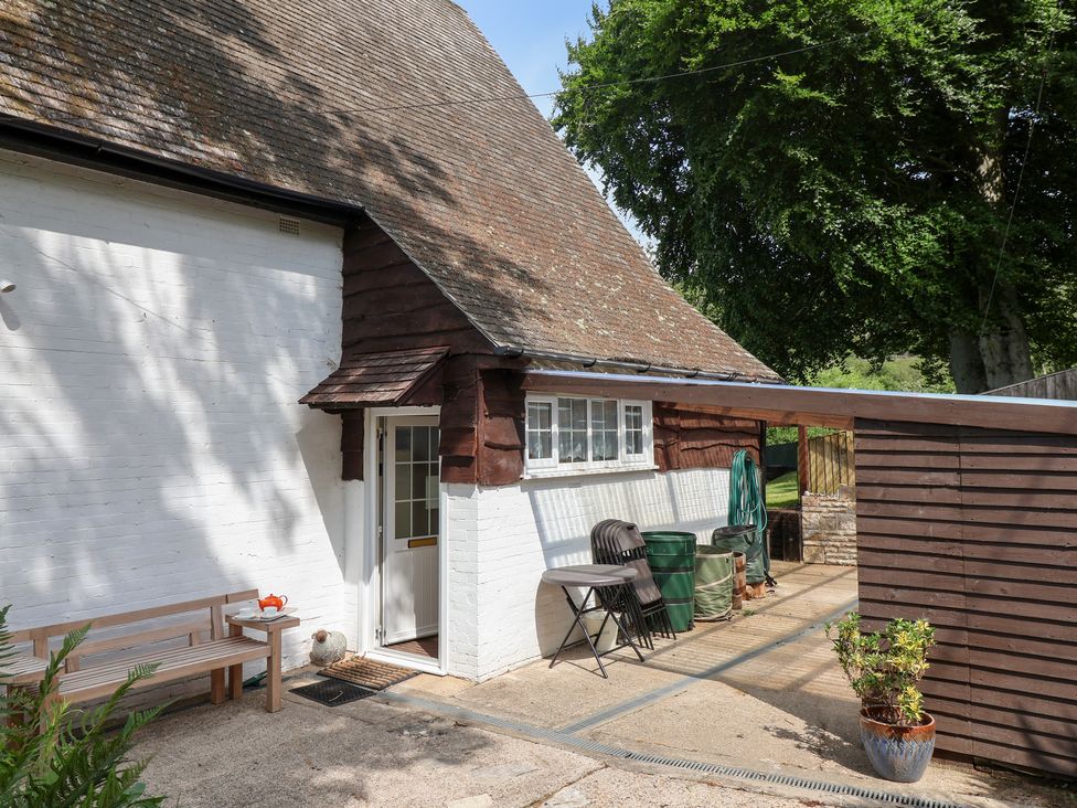 An outdoor area with a bench and table near the entrance at Barn Close Farm Morcombelake