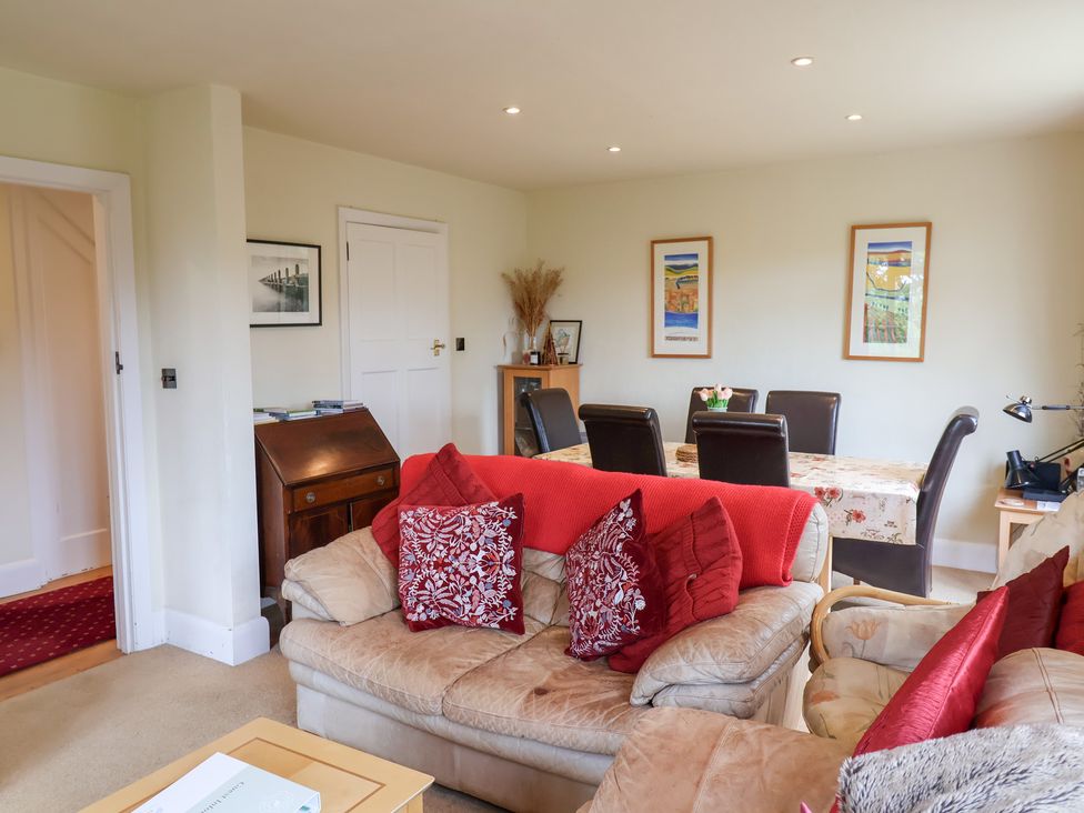 A living room with a sofa and dining table at Barn Close Farm in Morcombelake