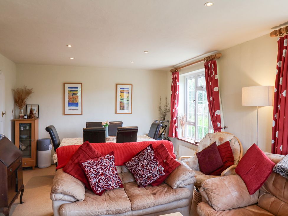 A living room with sofa and dining table at Barn Close Farm Morcombelake