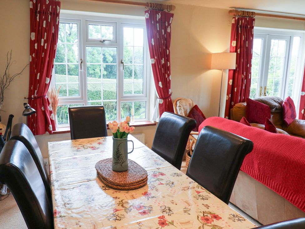 A dining room with a table and chairs at Barn Close Farm Morcombelake