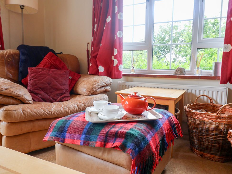 A living room with a sofa and a tea set at Barn Close Farm in Morcombelake