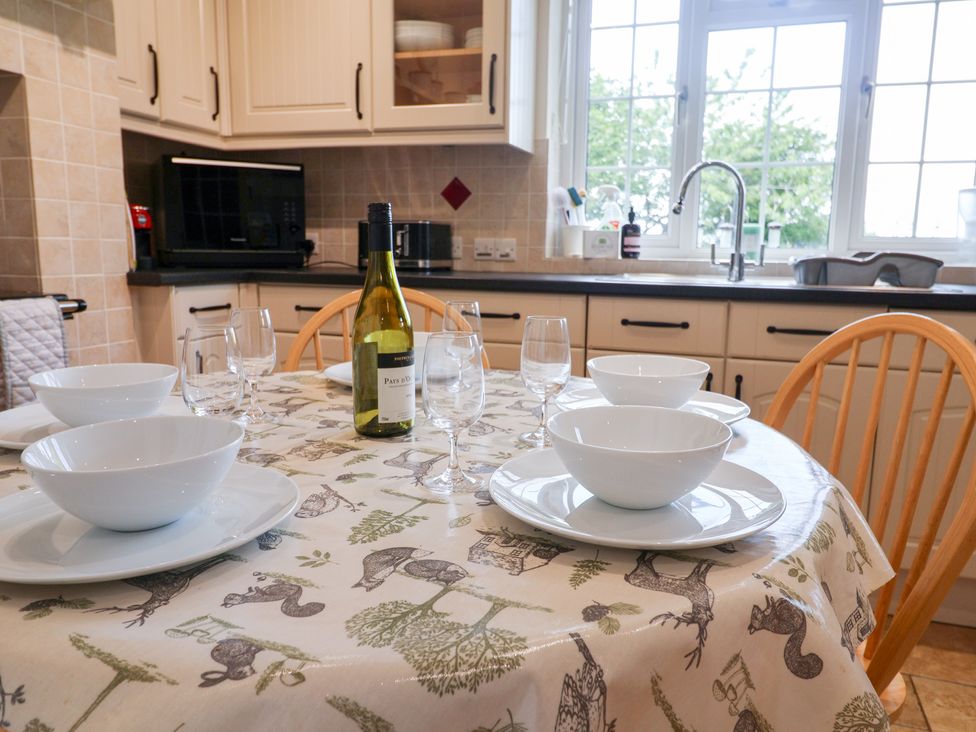 A kitchen with a table set for dining at Barn Close Farm in Morcombelake