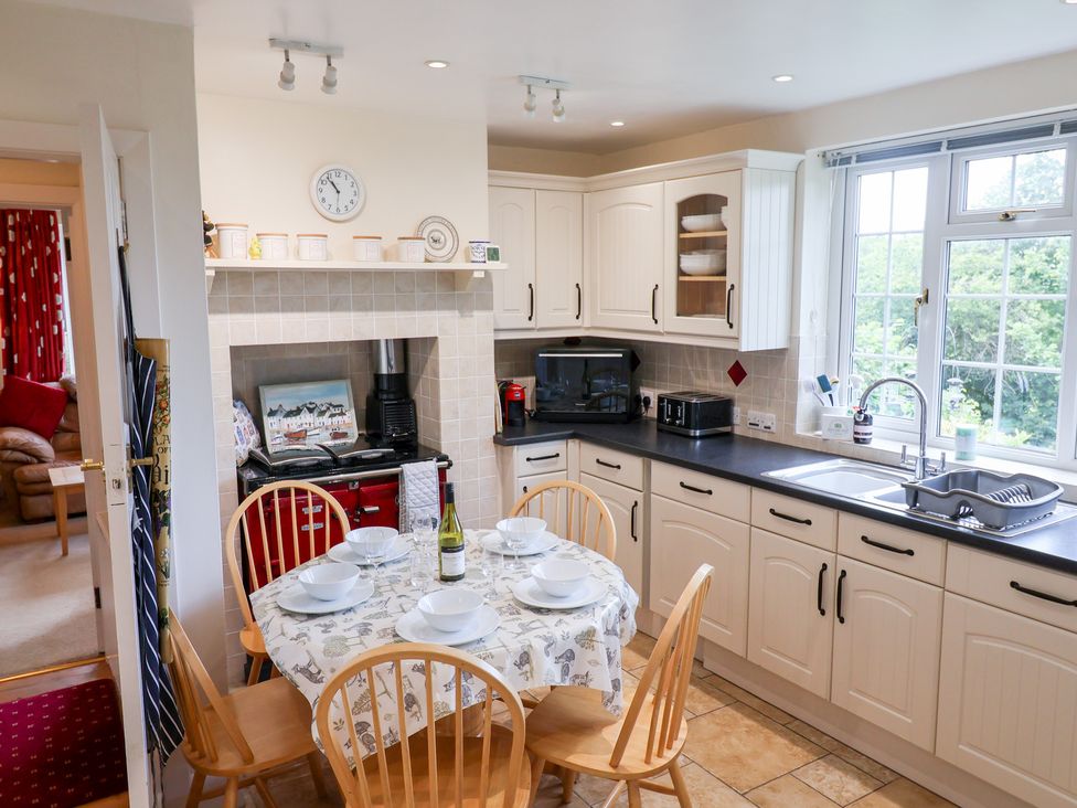 A kitchen with a dining table and chairs and appliances at Barn Close Farm in Morcombelake