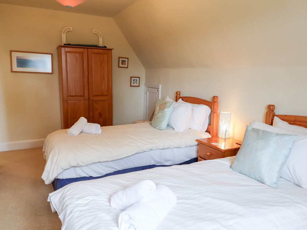 A bedroom with twin beds and a wardrobe at Barn Close Farm Morcombelake