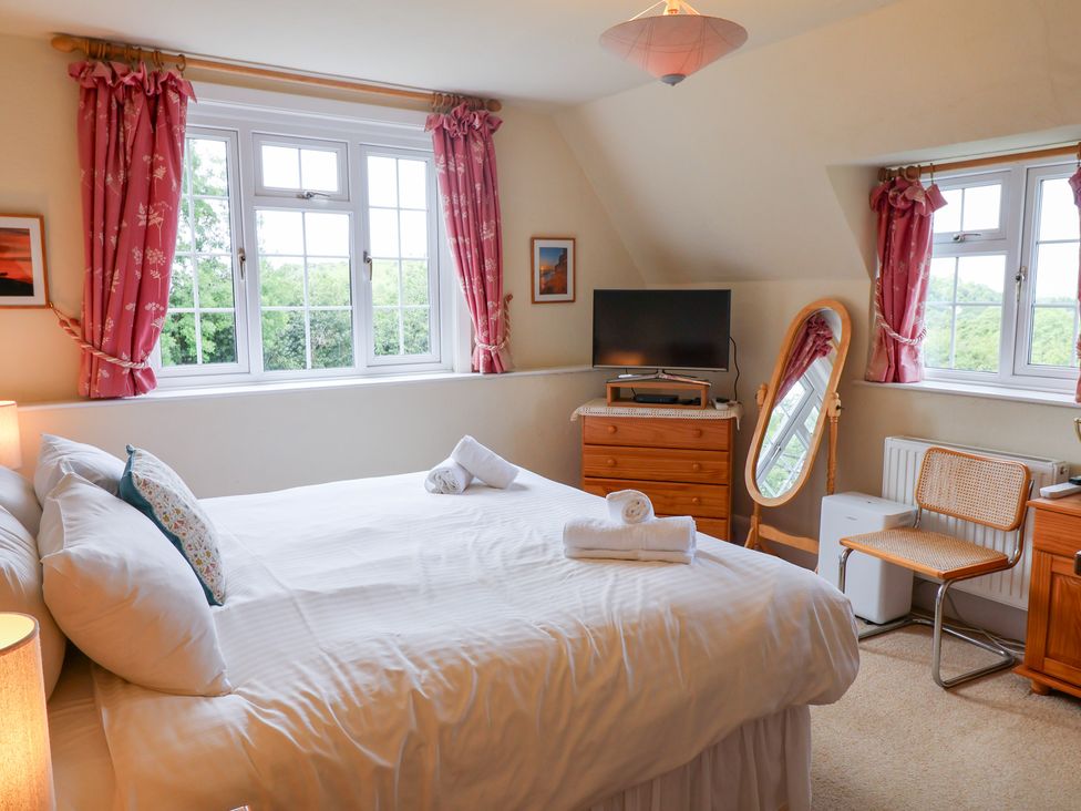 A bedroom with a bed and television at Barn Close Farm Morcombelake