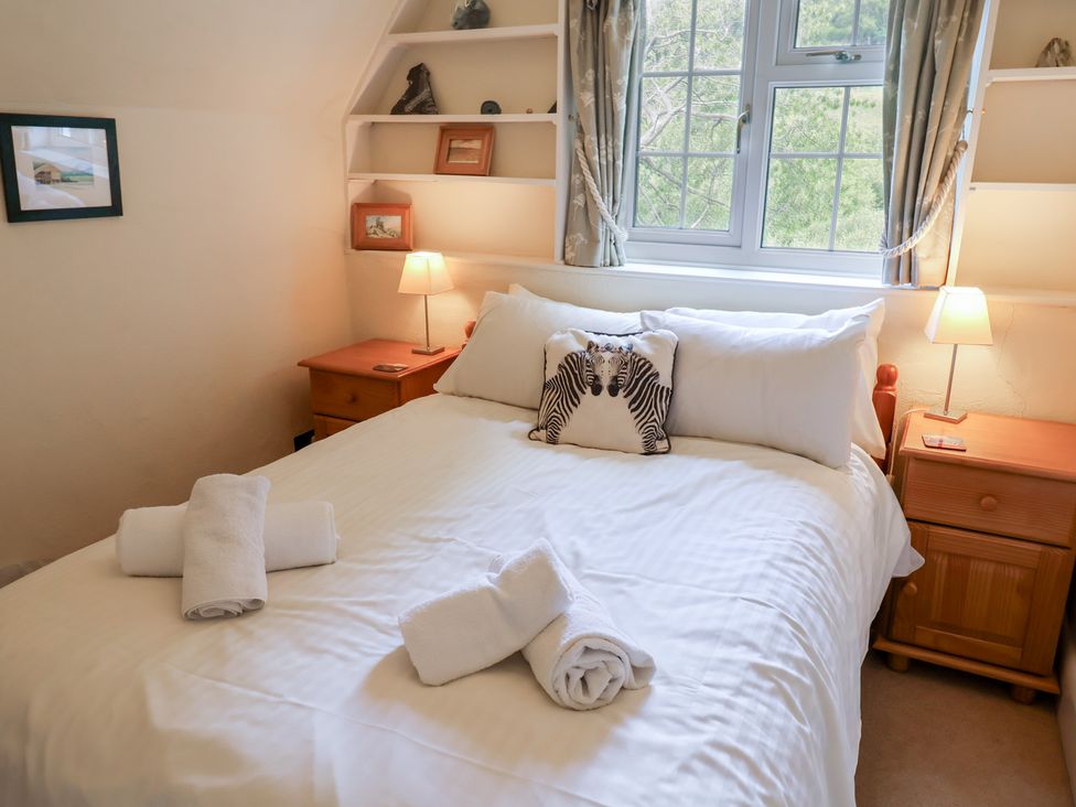 A bedroom with a bed and nightstands at Barn Close Farm Morcombelake