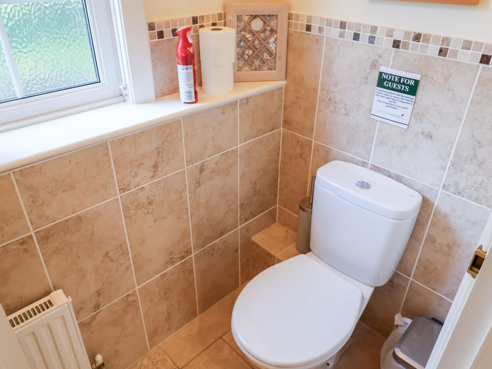 A bathroom with a toilet and sink area at Barn Close Farm in Morcombelake