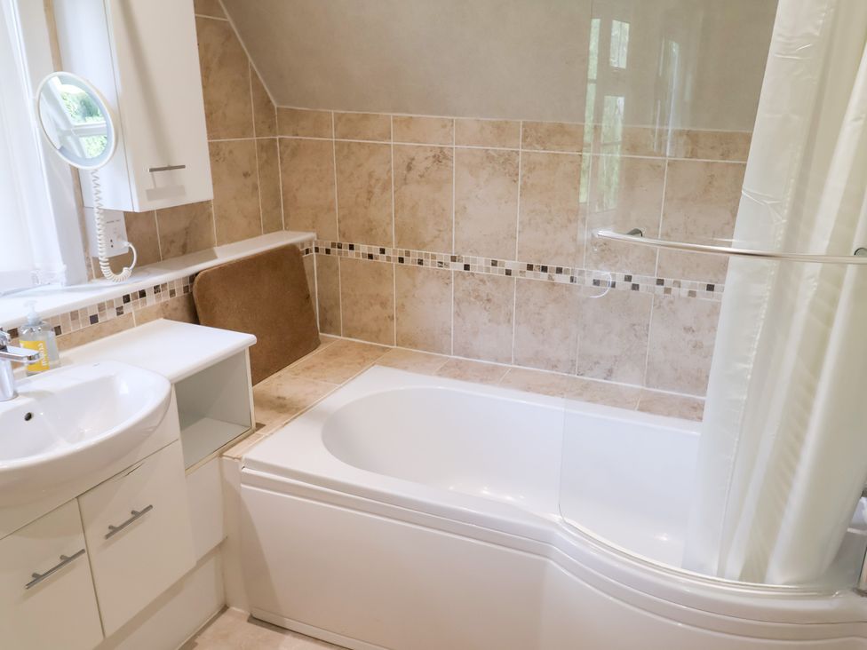 A bathroom with a bath and sink at Barn Close Farm Morcombelake