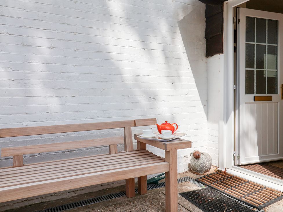 A bench with a teapot and cups near a door at Barn Close Farm Morcombelake