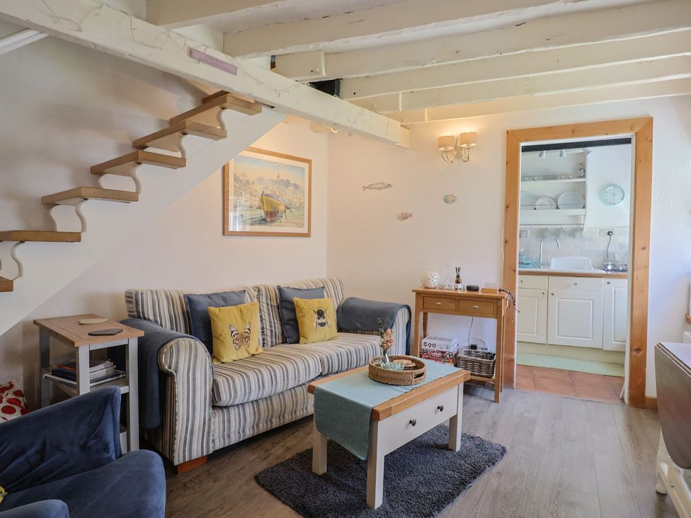A living room with a sofa and stairs at Cleve Cottage Lyme Regis