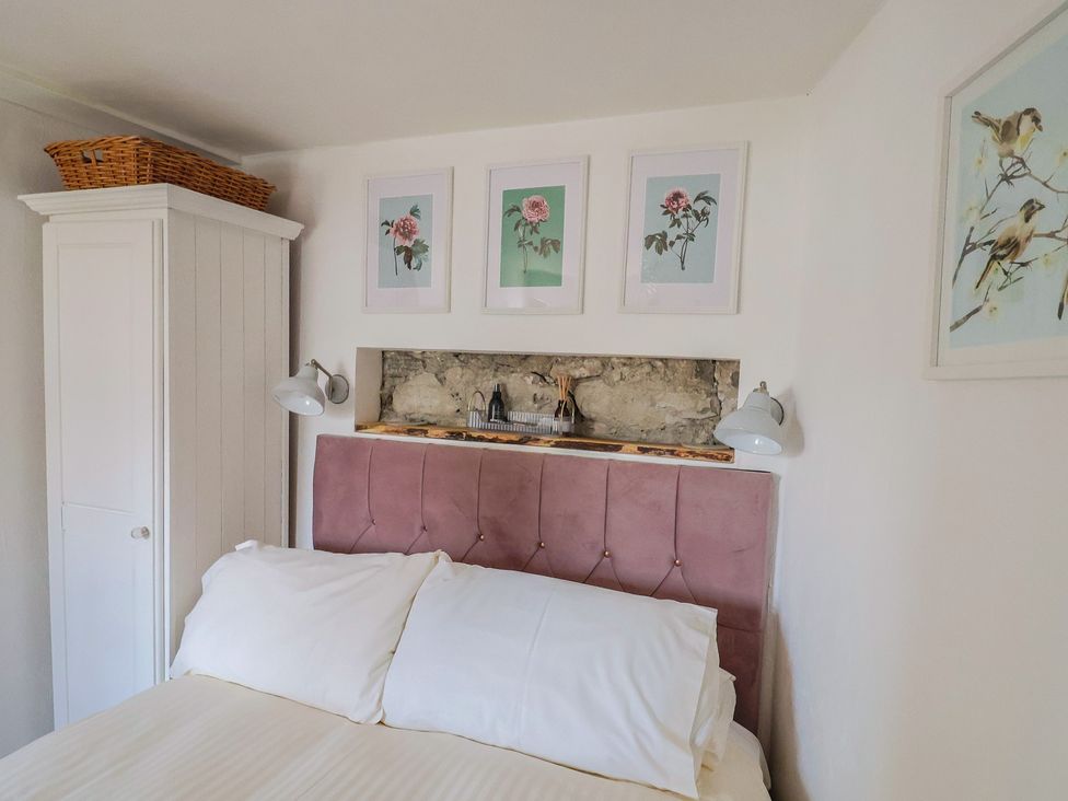 A bedroom with a bed and wardrobe at Cleve Cottage in Lyme Regis