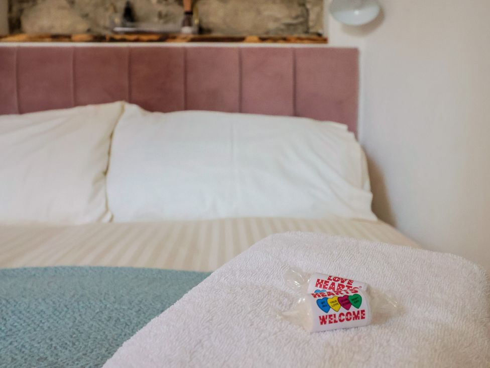 A bed with pillows and a towel in the bedroom at Cleve Cottage in Lyme Regis
