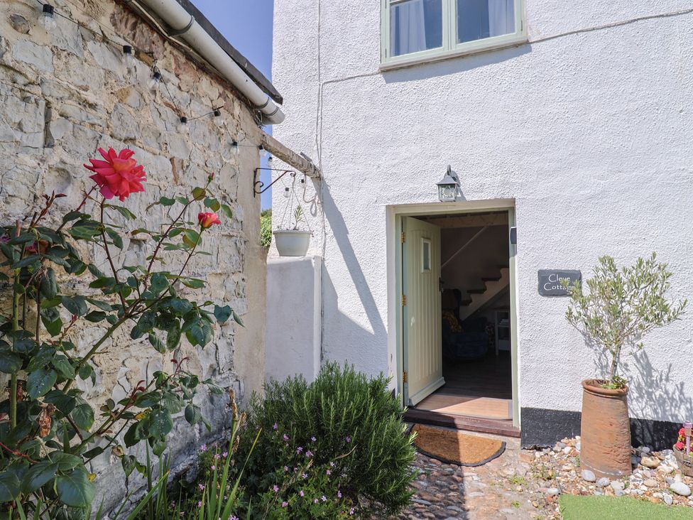 An entrance with a flower and stone wall at Cleve Cottage in Lyme Regis
