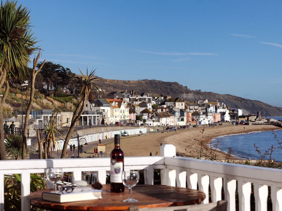 A beach view with houses and palm trees at 1 Wellhayes Lyme Regis