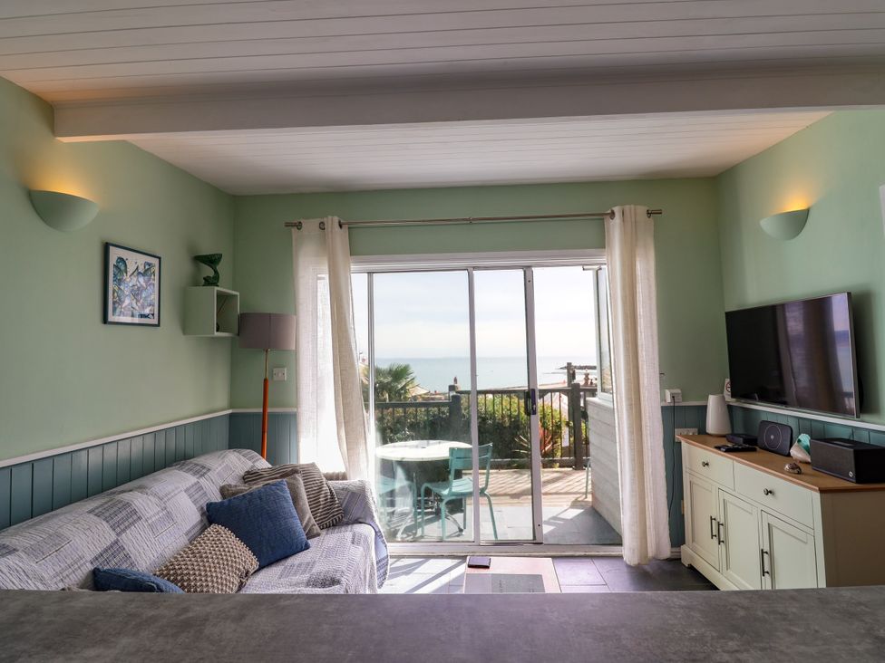 A living room with a sofa and a view of the sea at 1 Wellhayes Lyme Regis