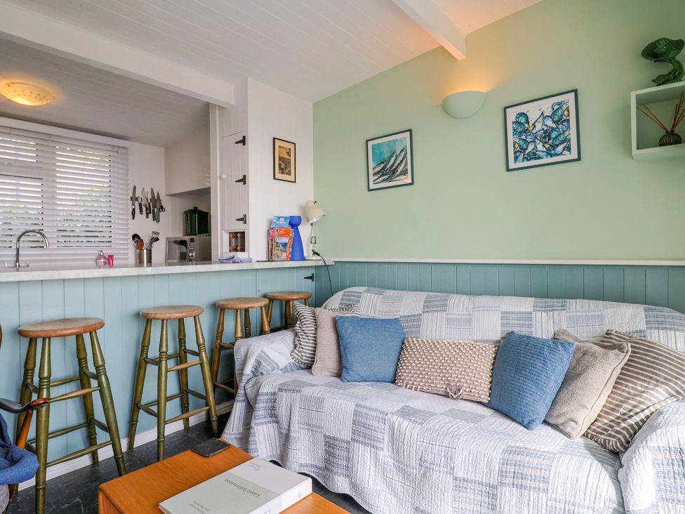 A living room with a sofa and bar stools at 1 Wellhayes Lyme Regis