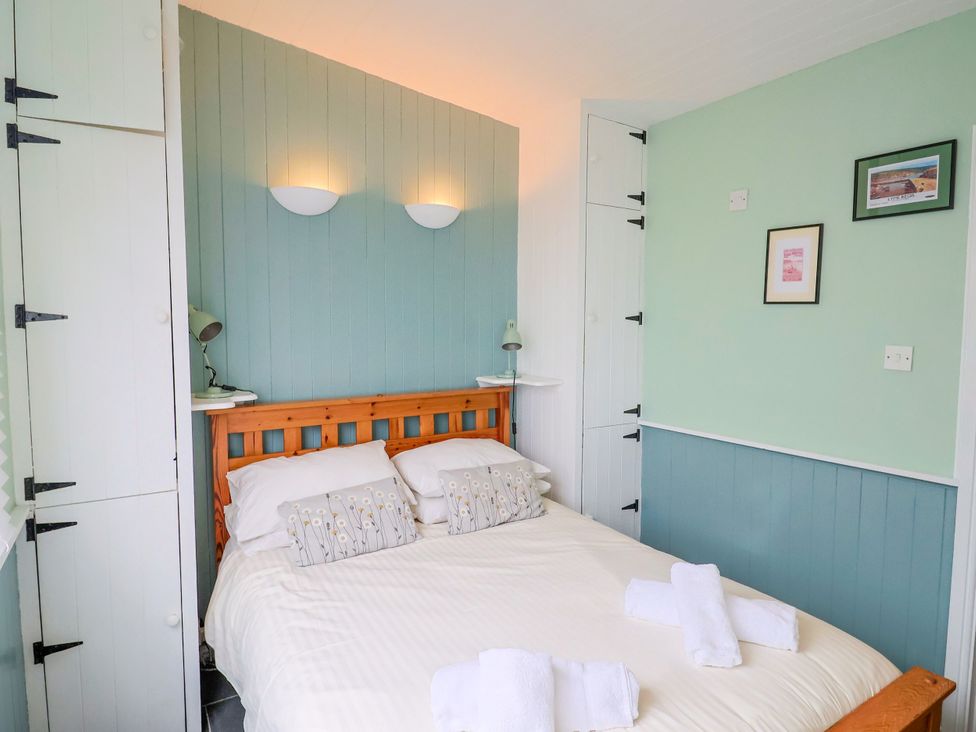 A bedroom with a bed and storage units at 1 Wellhayes in Lyme Regis