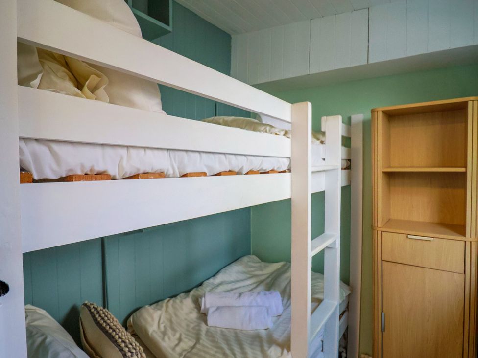 A bedroom with bunk beds and storage unit at 1 Wellhayes in Lyme Regis