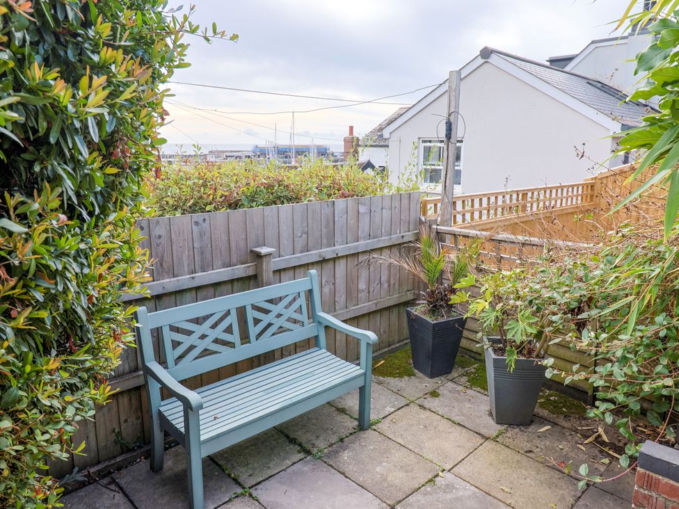 A garden with a bench and potted plants at 1 Wellhayes in Lyme Regis