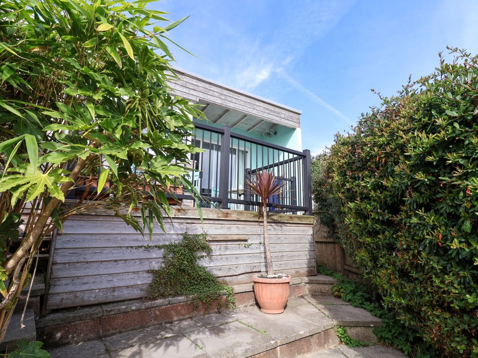 A garden area with a wooden deck and plants at 1 Wellhayes Lyme Regis