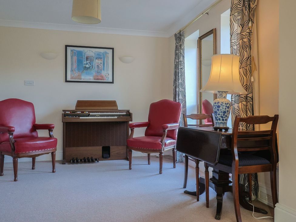 A living room with two armchairs and a keyboard at High Cliff Orchard in Lyme Regis