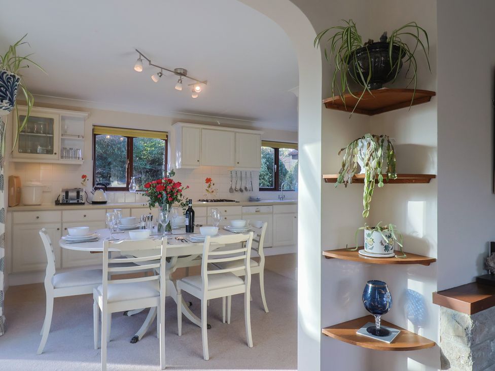 A kitchen with a table and chairs at High Cliff Orchard in Lyme Regis