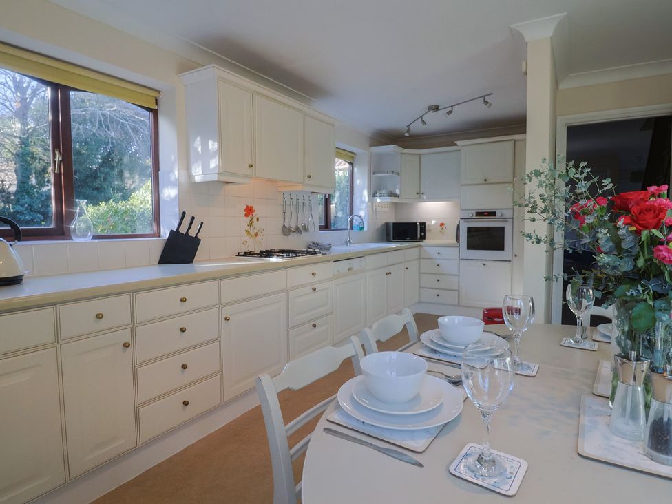 A kitchen with cabinets and a table set at High Cliff Orchard in Lyme Regis