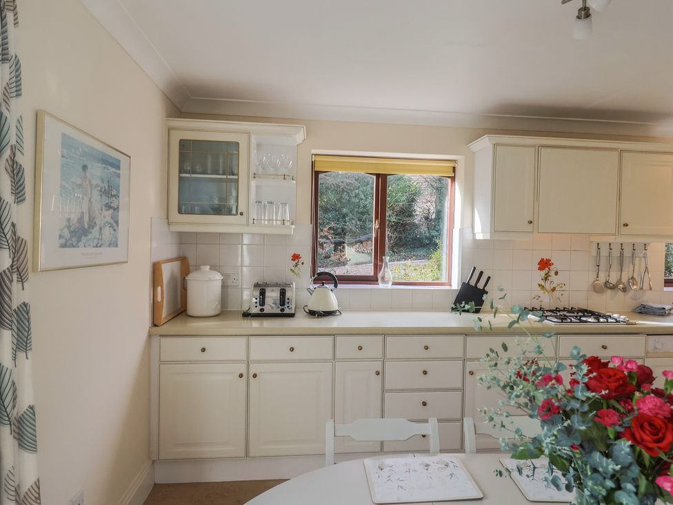 A kitchen with a table and chairs at High Cliff Orchard in Lyme Regis
