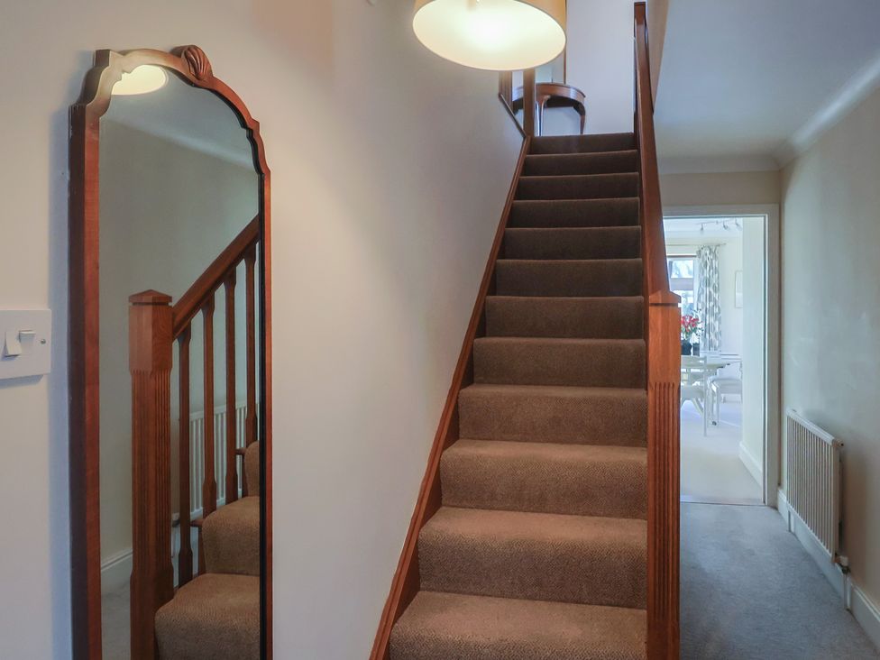 A hallway with stairs and a mirror at High Cliff Orchard in Lyme Regis