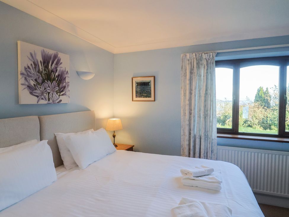 A bedroom with a bed and lamp at High Cliff Orchard in Lyme Regis