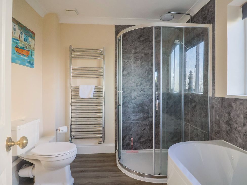 A bathroom with a shower, bathtub, and toilet at High Cliff Orchard in Lyme Regis
