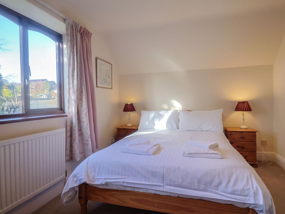 A bedroom with a bed and bedside tables at High Cliff Orchard in Lyme Regis