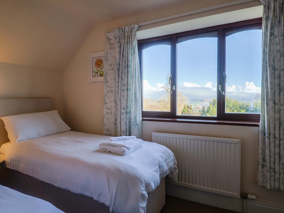 A bedroom with two beds and a window at High Cliff Orchard in Lyme Regis