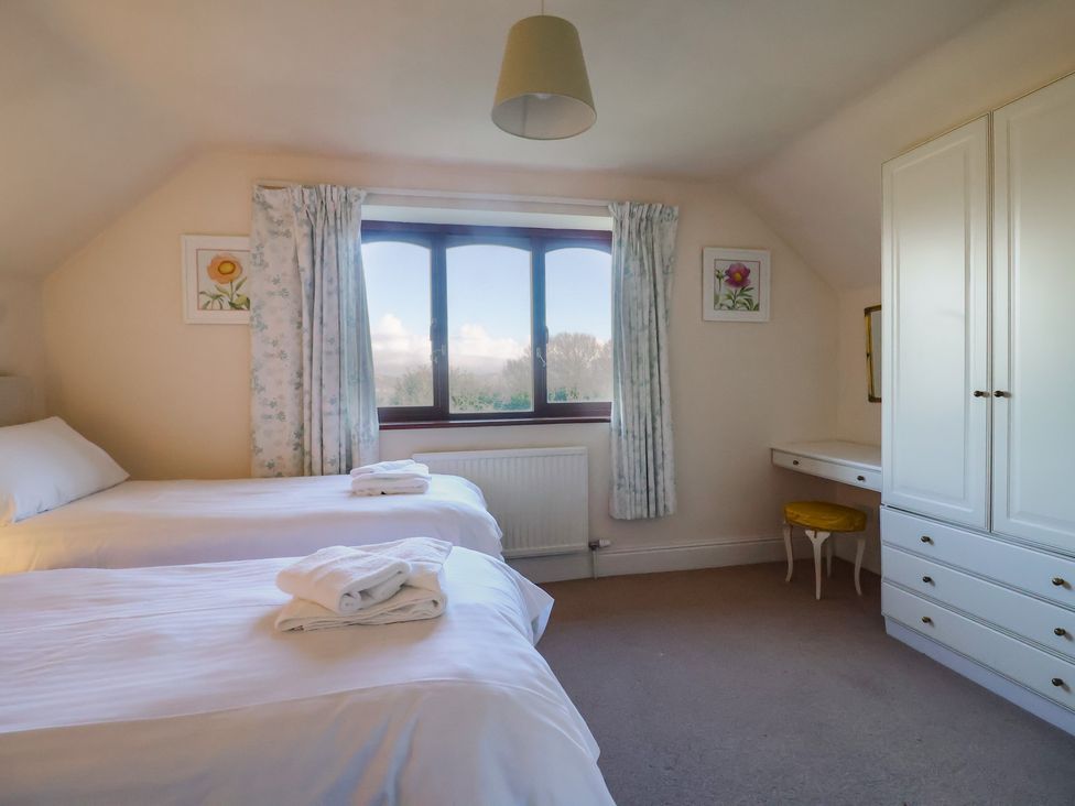 A bedroom with two beds and a window at High Cliff Orchard in Lyme Regis