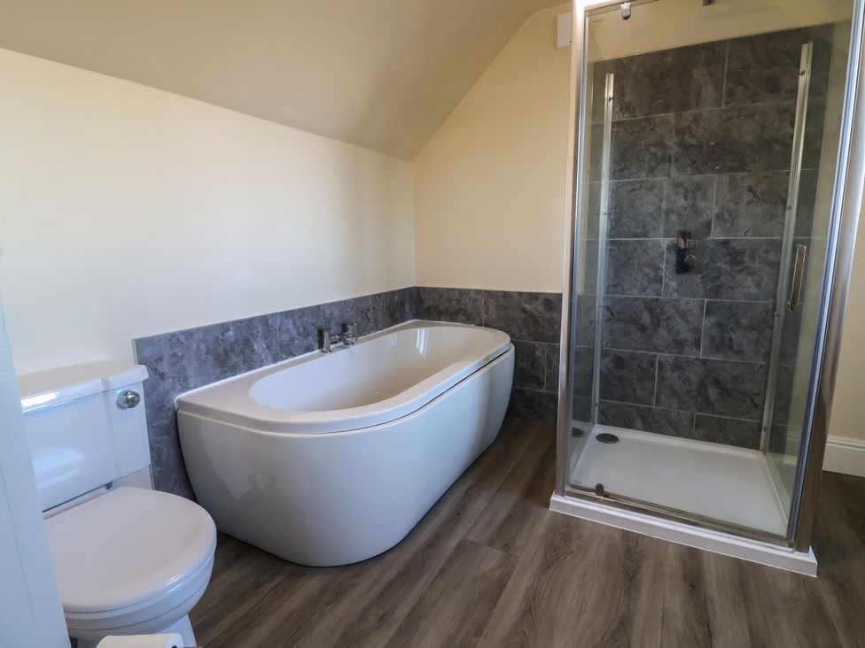 A bathroom with bathtub, toilet and shower at High Cliff Orchard in Lyme Regis