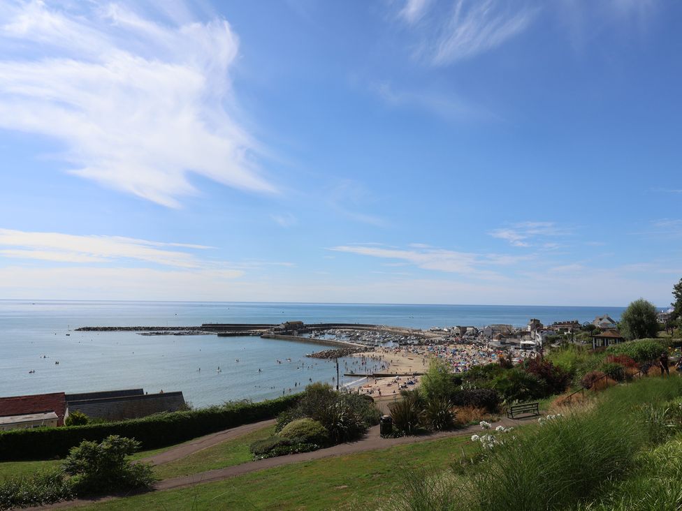 A beach with people and boats at High Cliff Orchard in Lyme Regis