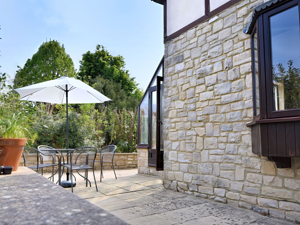 An outdoor patio area with a table and chairs at High Cliff Orchard in Lyme Regis