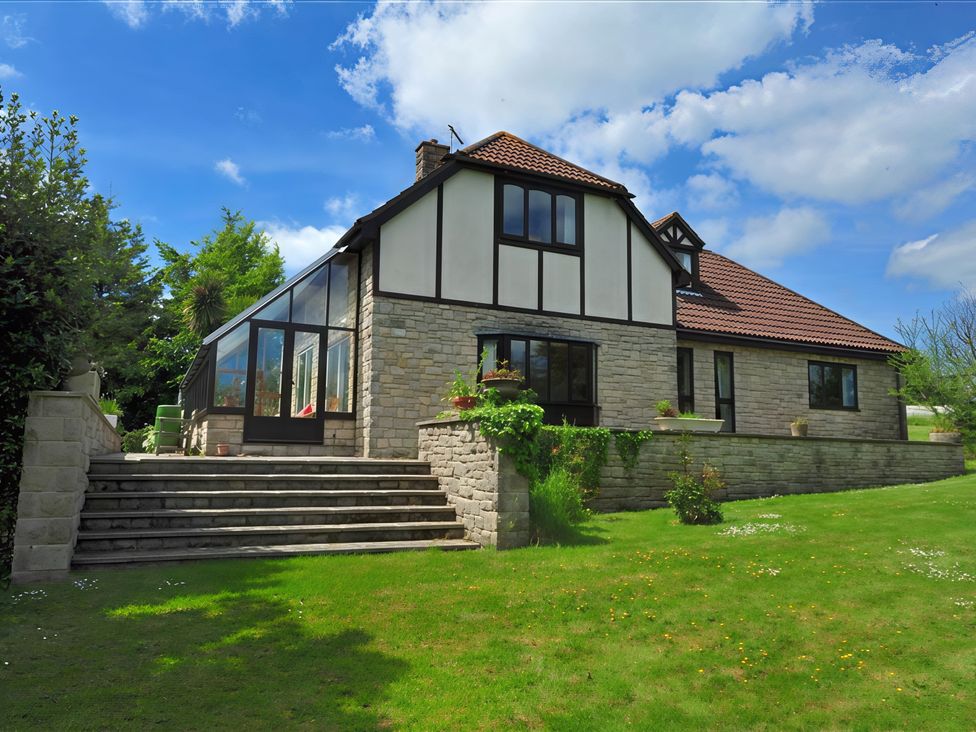 A house with large windows and a garden at High Cliff Orchard in Lyme Regis