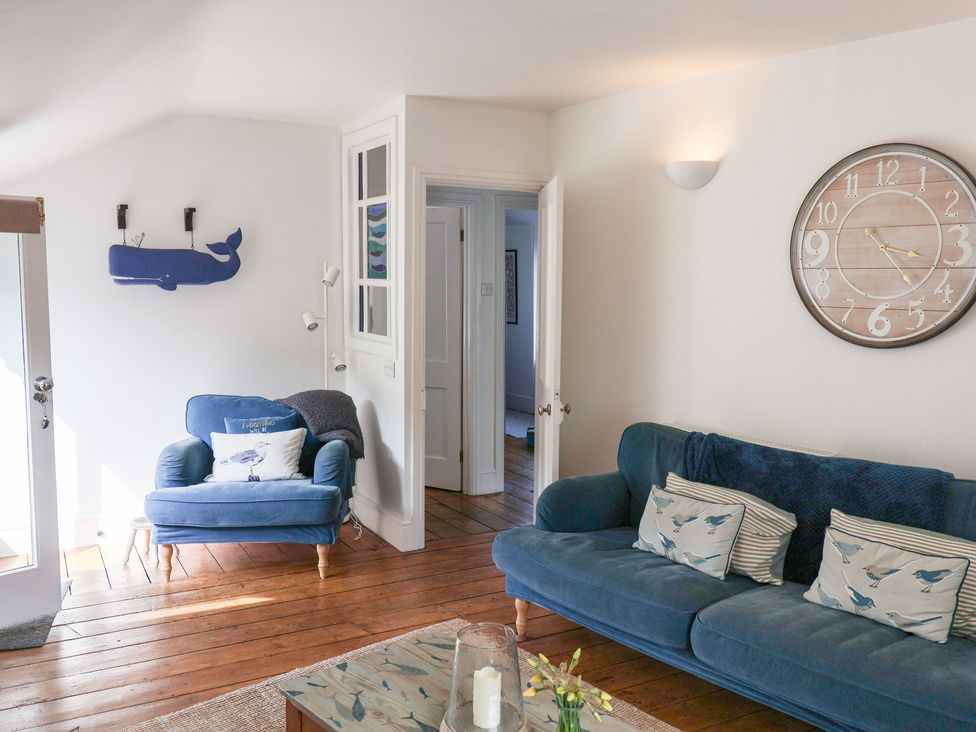 A living room with a blue sofa and armchair at The Bakehouse in Lyme Regis