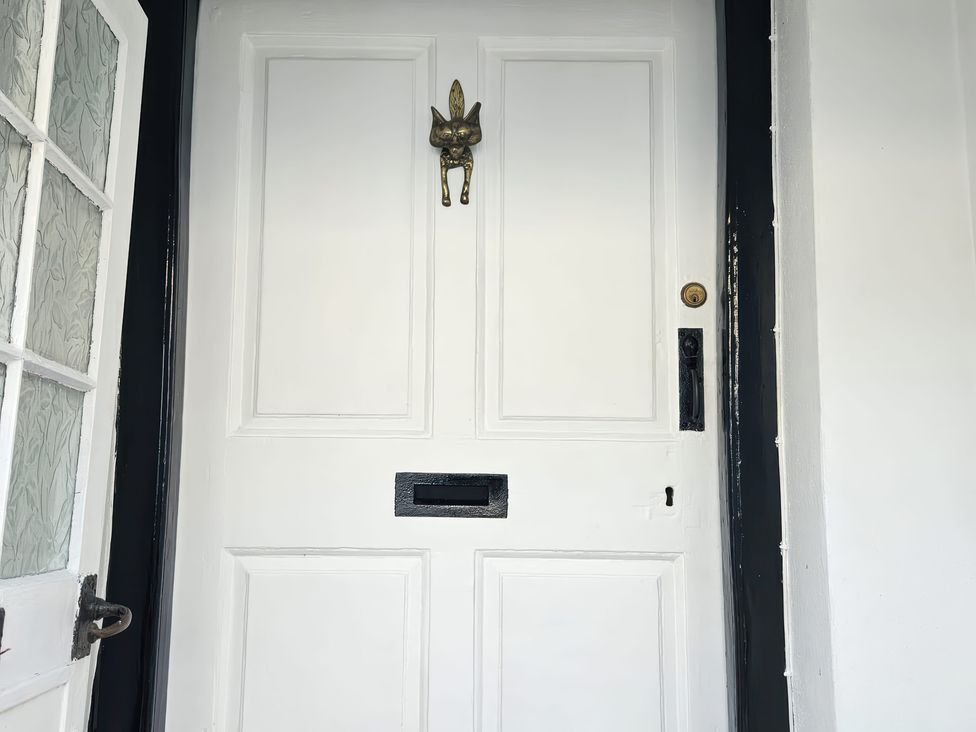 A front door with a knocker and mail slot at Foxley Cottage in Charmouth