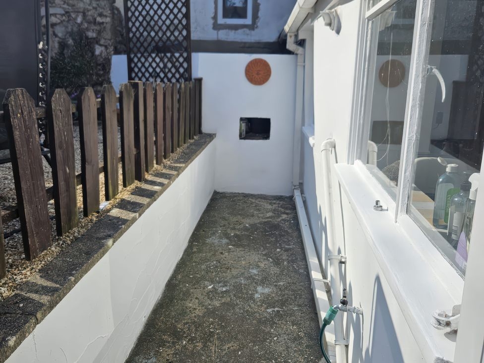 An outdoor area with a fence and window at Foxley Cottage in Charmouth