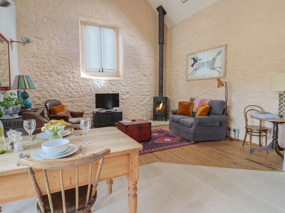 A living room with a dining table and sofa at The Stone Barn in Bridport