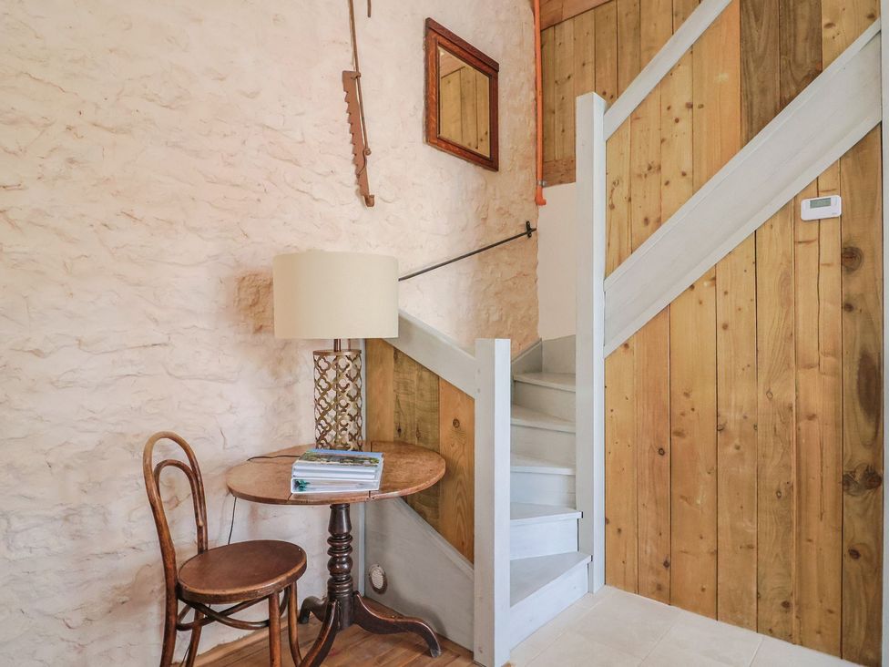 A staircase with a table and chair at The Stone Barn in Bridport