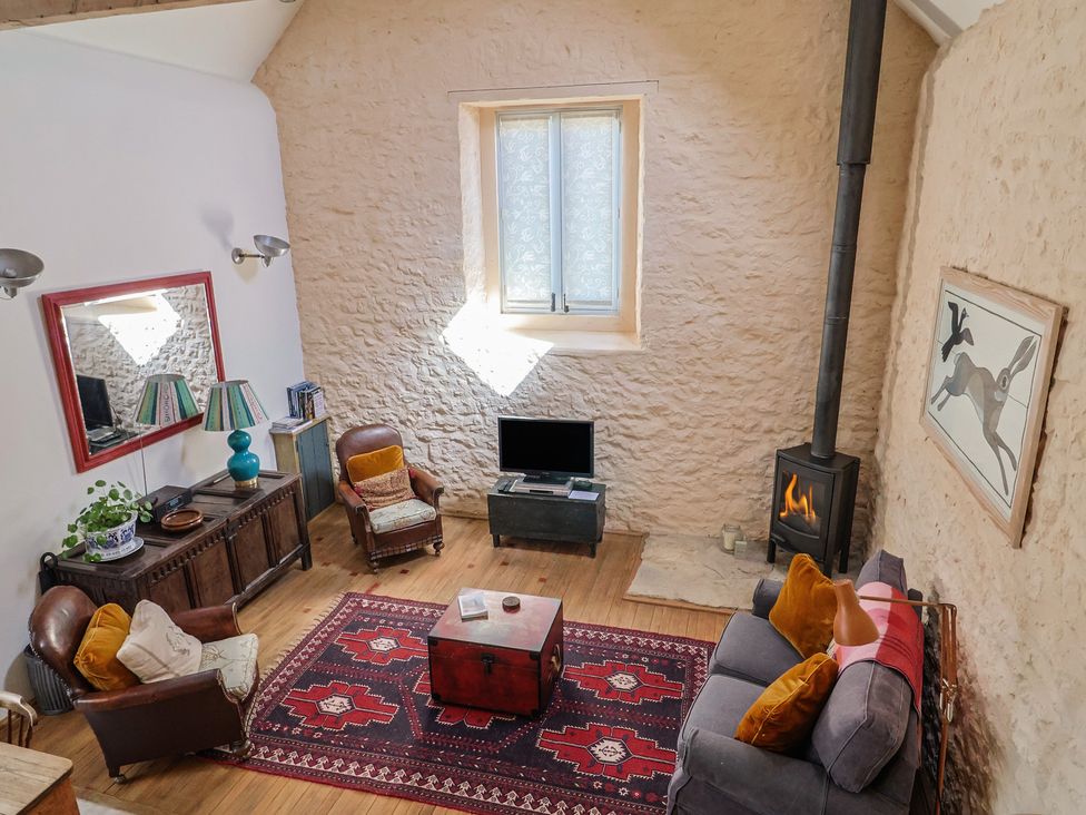 A living room with a sofa and fireplace at The Stone Barn in Bridport
