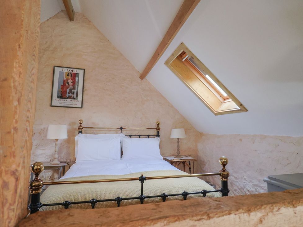 A bedroom with a bed and a lamp at The Stone Barn in Bridport