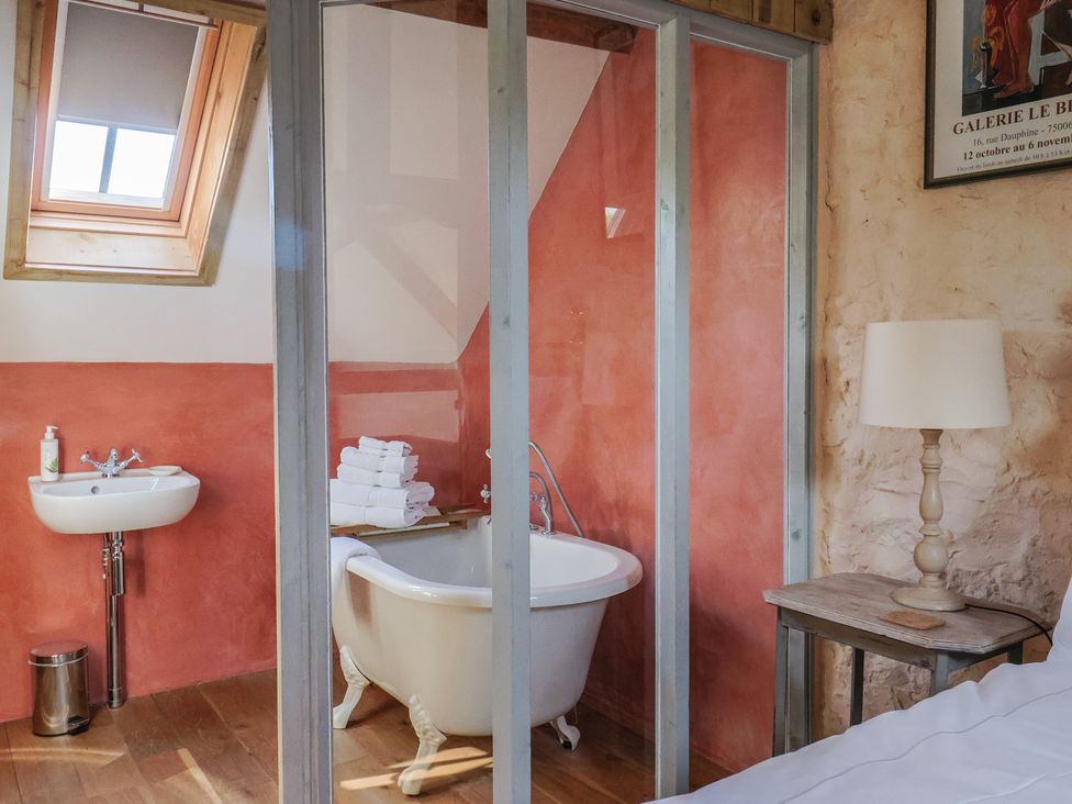 A bathroom with a bathtub and sink at The Stone Barn in Bridport